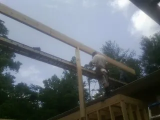 Carpenter setting a ridge beam over a new addition frame — Ice Dam Removal by Roofing Brothers in West Springfield
