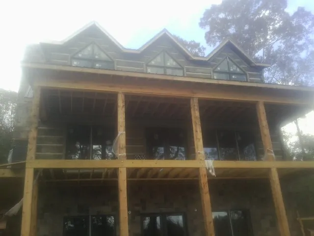 Dormers and porch framing on a large log home under construction — Roof Coating work by our crew in West Springfield